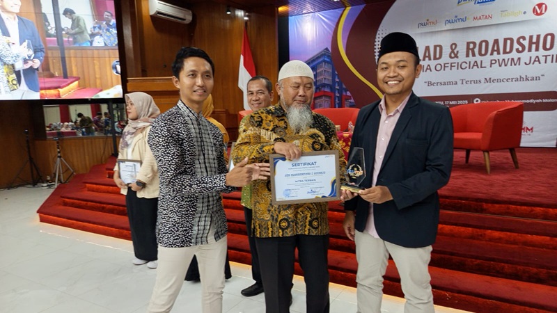 Arif Hanafi, Waka Kesiswaan Smamda Sidoarjo menerima penghargaan Mitra Terbaik dari Zainul Muslimin (tengah), Bendahara PWM Jawa Timur didampingi Redaktur PWMU.CO, Azrohal Hasan di UMM, Sabtu (17/05/2025). (Moh. Ernam/smamda.sch.id)